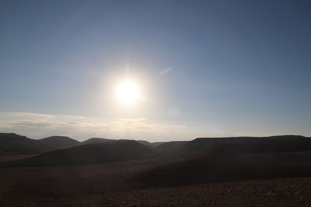 Man sieht eine Mittagsszene in der Wüste. Die Sonne scheint.
